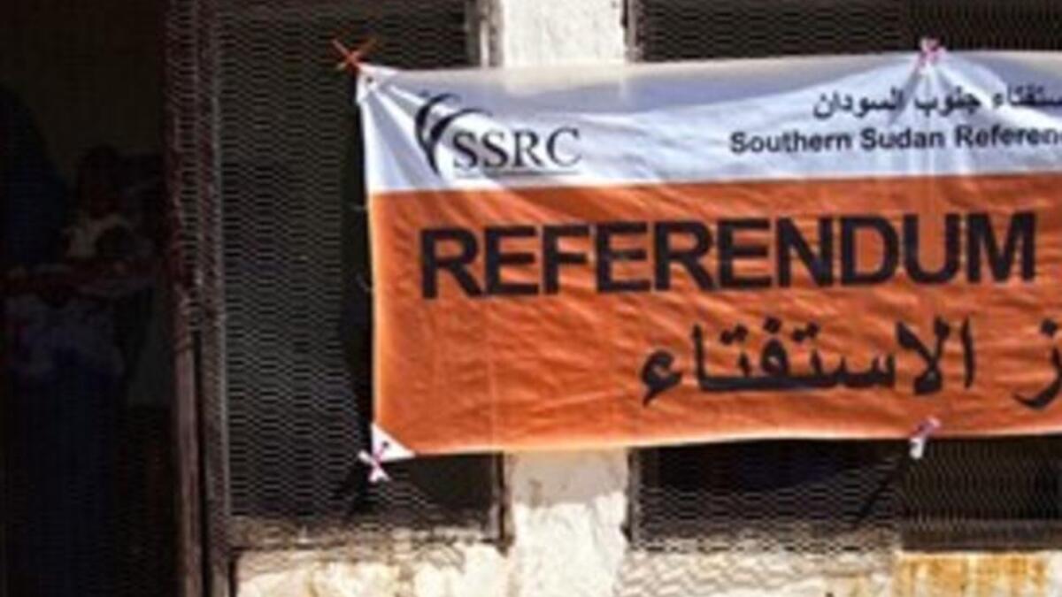 a Southern Sudanese woman carries her baby as she leaves after registering at a center to vote in the upcoming referendum on the south's independence from the north, in al-Fasher, the capital of north Darfur.