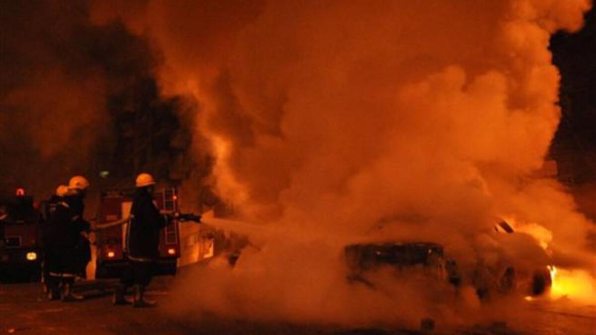 Egyptian firefighters extinguish flames from a vehicle that caught fire following a car bomb attack outside the Al-Qiddissine church.