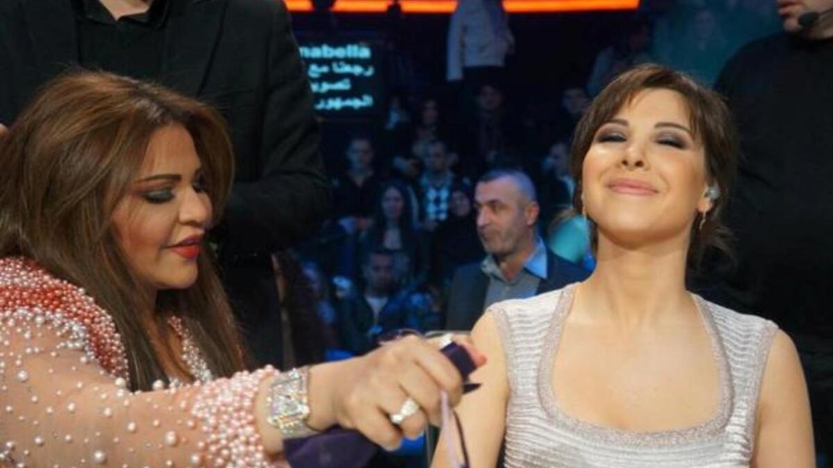 Ahlam sprays perfume on Nancy Ajram for Arab Idol