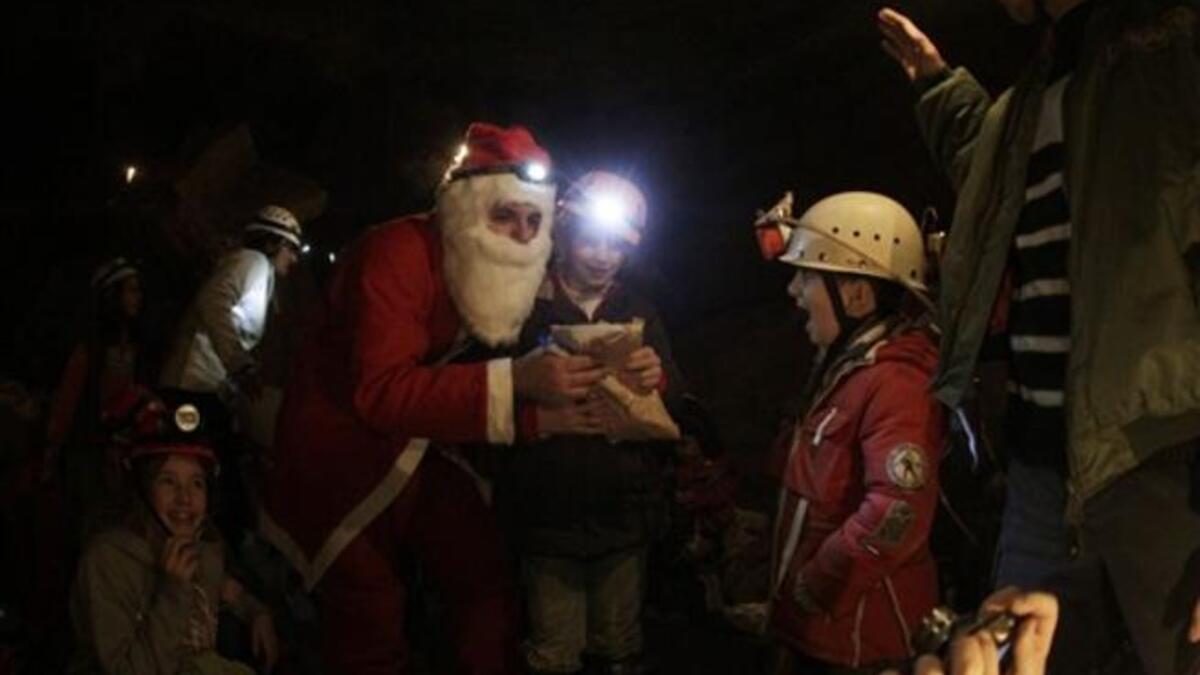A Lebanese caver from the(ALES) disguised as Santa Claus, distributes gifts to children of the Association members and their comrades as the cavers celebrate with them Christmas inside a cave in the village of Rweiss nearly at 2000 meters above sea level in the Lebanese mountains north of Beirut.
