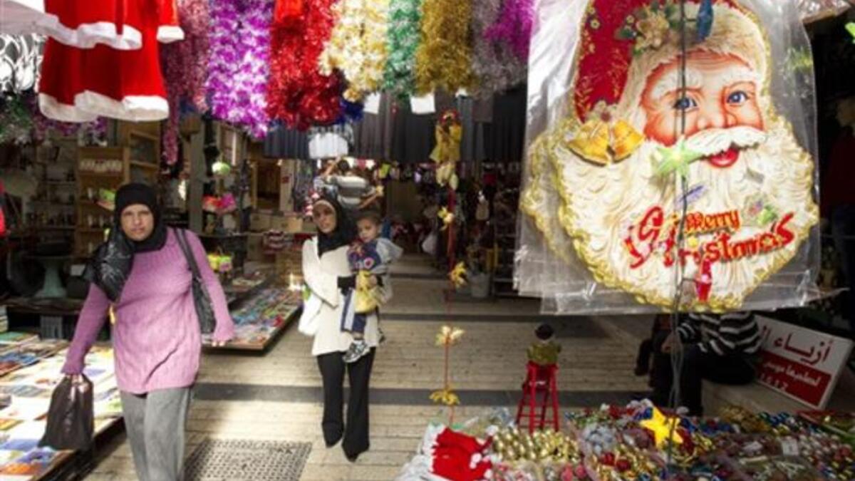 Arab-Israeli women walk past stalls selling Christmas decorations at a market in the Arab-Israeli town of Nazareth.
