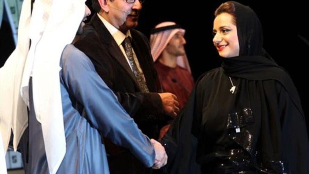 Emirati film director Nayla al-Khaja shakes hands with Sheikh Mansur bin Mohammed bin Rashed al-Maktoum (L).