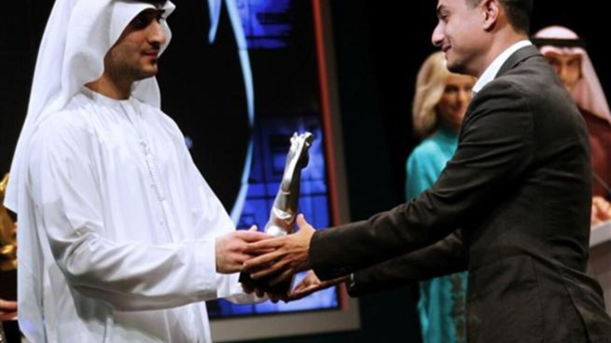 Sheikh Said bin Mohammed bin Rashed al-Maktoum (L) hands the special international jury award to Mohammed al-Hushki for his film Transit Cities.