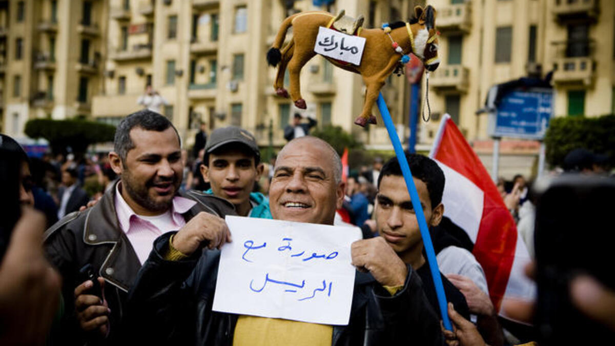 An Egyptian man is holding a placard that reads "A photo with the president". (Photo by 3arabawy - صَحـَـفي مِصـْـري.)