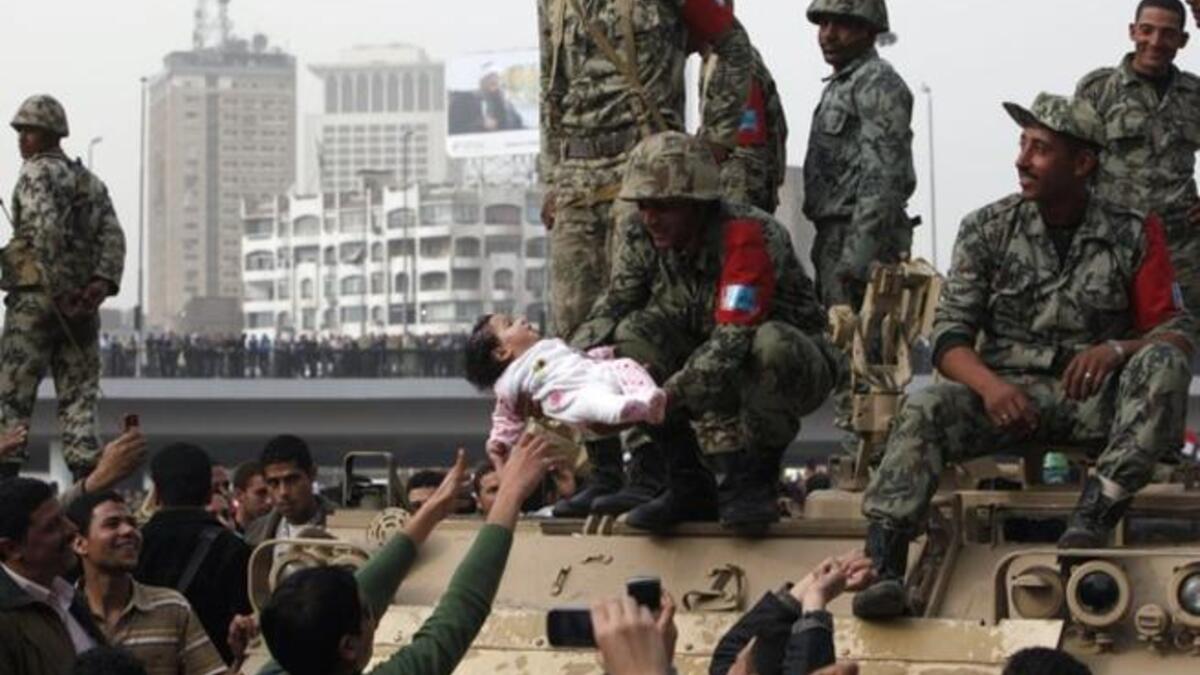 An Egyptian soldier raises an infant of the Protest in testimony to the good feeling between the Military and the People this last week.