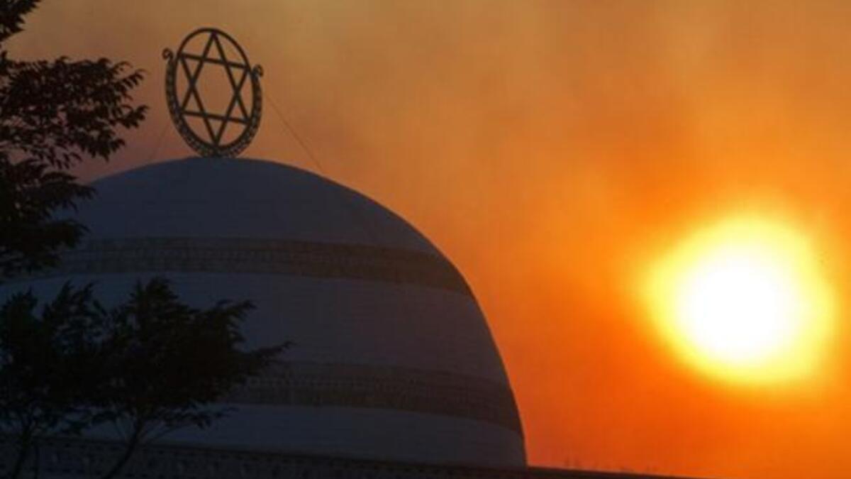The sun rises amidst smoke of ongoing fire in Tirat Ha Carmel near the northern city of Haifa.