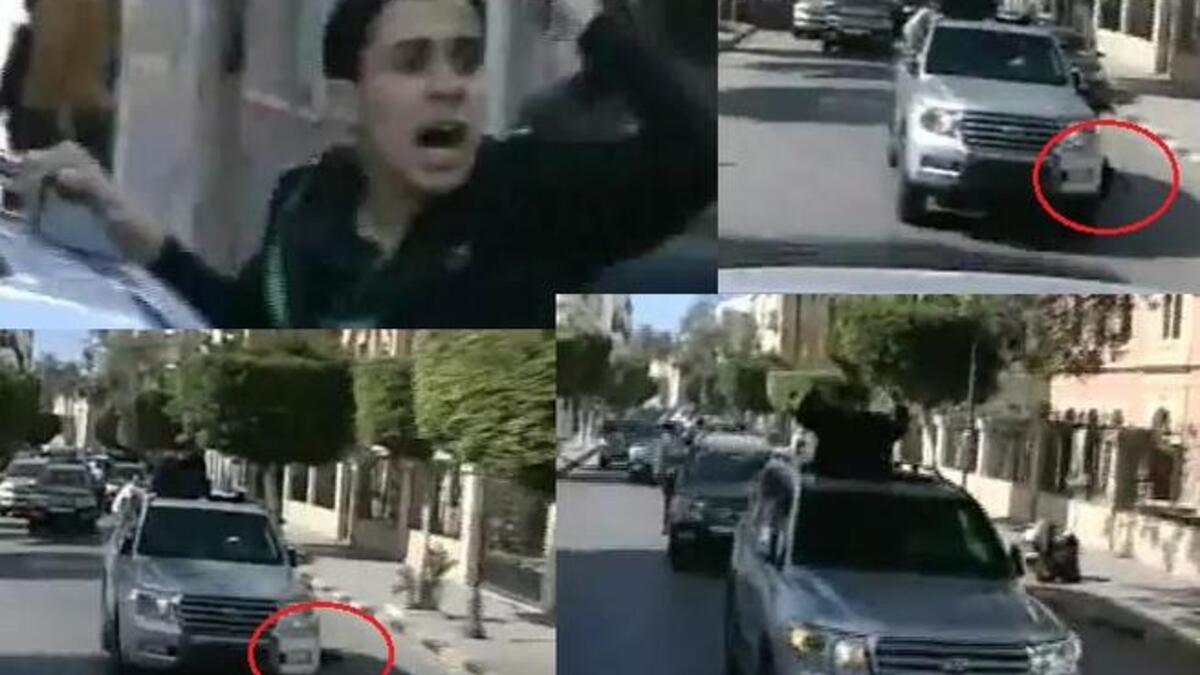 Fist-air-punching Gaddafi on his latest public outing:– his boy supporter falls flat from the Gaddafi-car-mobile, and Gaddafi only momentarily glances at him before carrying on thumping the air, unfazed.