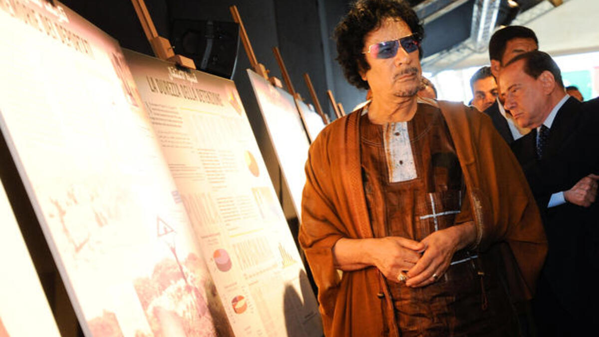 Like a "Rock Star" Gaddafi attends the photo exhibition wearing his shades!