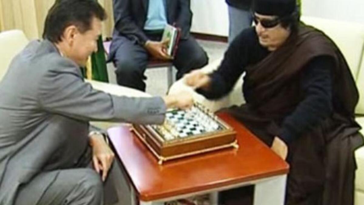 Still playing games with us, Moammar? Always full of surprises: as the world waits for his next move we can count on him to keep it flamboyant and bizarre. Here seen on Libyan state TV in June, the Libyan leader has been playing chess with
the visiting Russian head of the World Chess Federation.