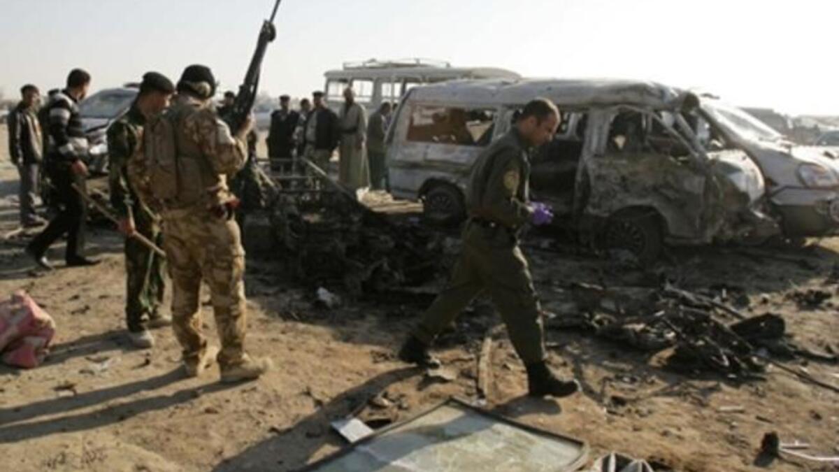 Members of Iraq security forces gather on the site of an explosion in Karbala. As a spate of attacks across Iraq killed at least 50 people, most of them in twin suicide car bombings in the holy city of Karbala, the third major attack in as many days.
