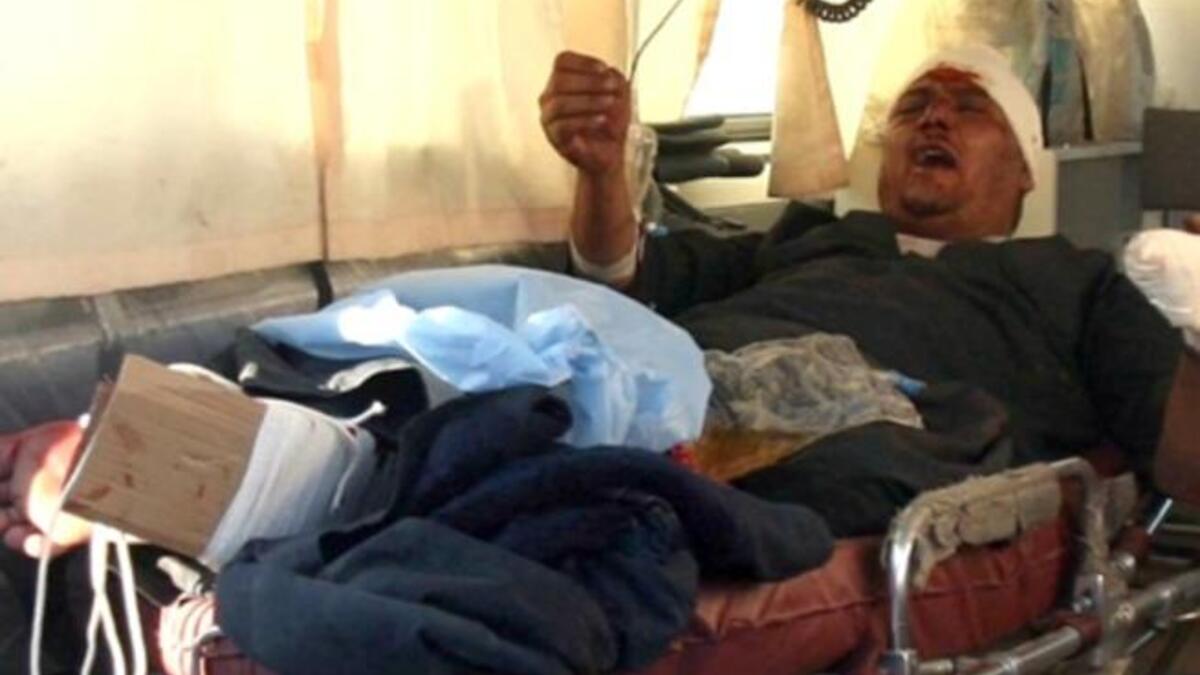 An injured Iraqi waits in the back of an ambulance in Karbala.