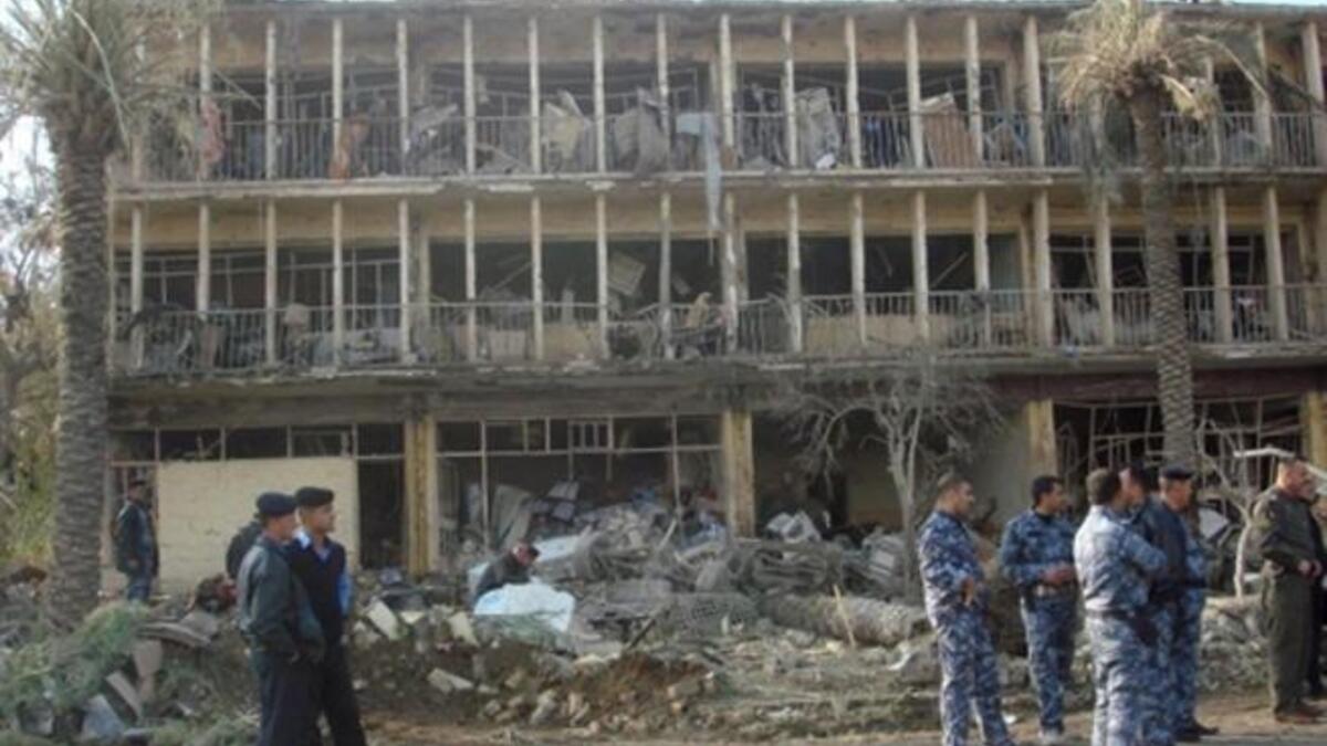 Members of Iraqi security forces gather next to the ruins of the Baquba headquarters of the Force Protection Service (FPS), where a suicide bomber rammed an ambulance packed with explosives killing 13 people.