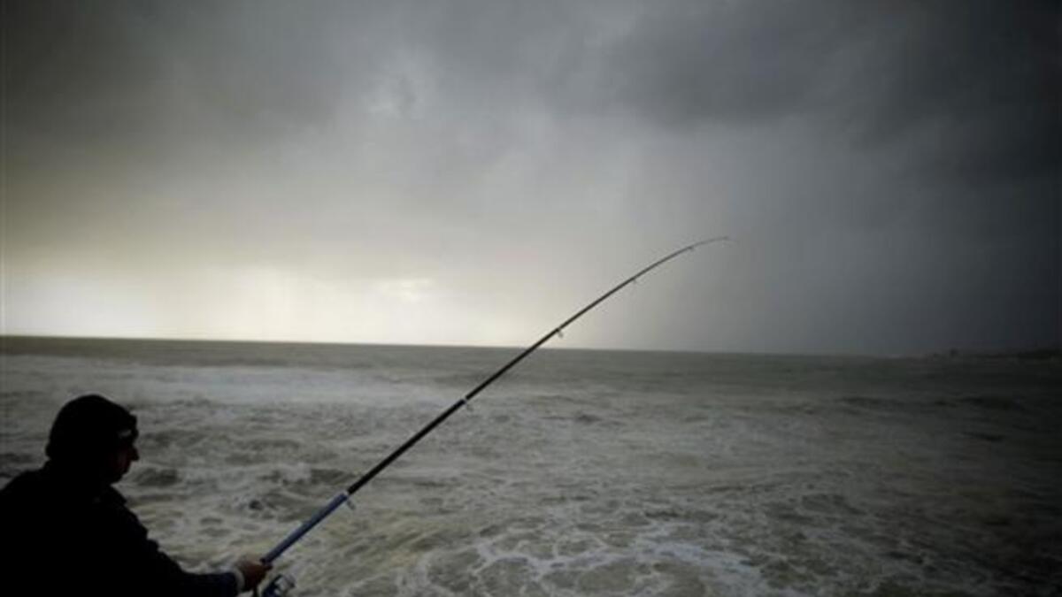 A Lebanese man fishes during a storm on the Mediterranean coast off the northern Lebanese port of Byblos.