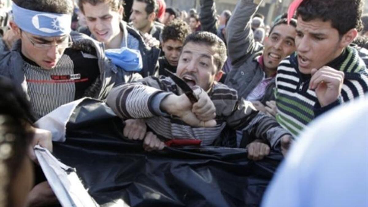 Supporters of the Future Movement rip a poster of Lebanese MP Najib Mikati during a demonstration in support of the caretaker prime minister Saad Hariri.