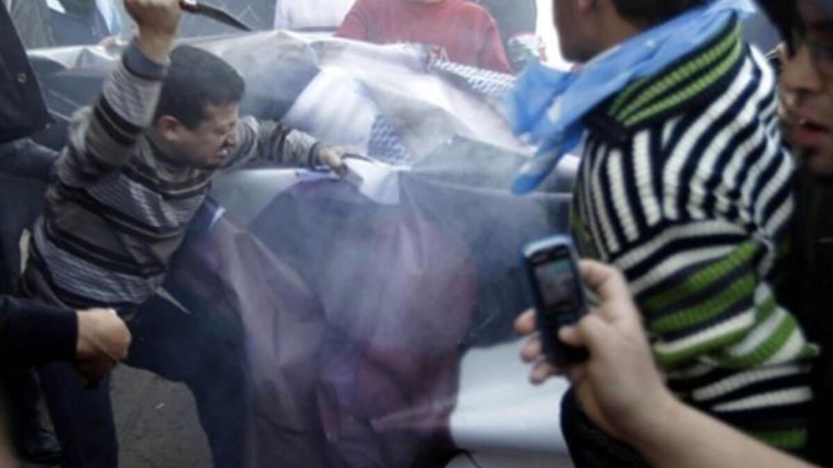 Supporters of the Future Movement rip a poster of Lebanese MP Najib Mikati.