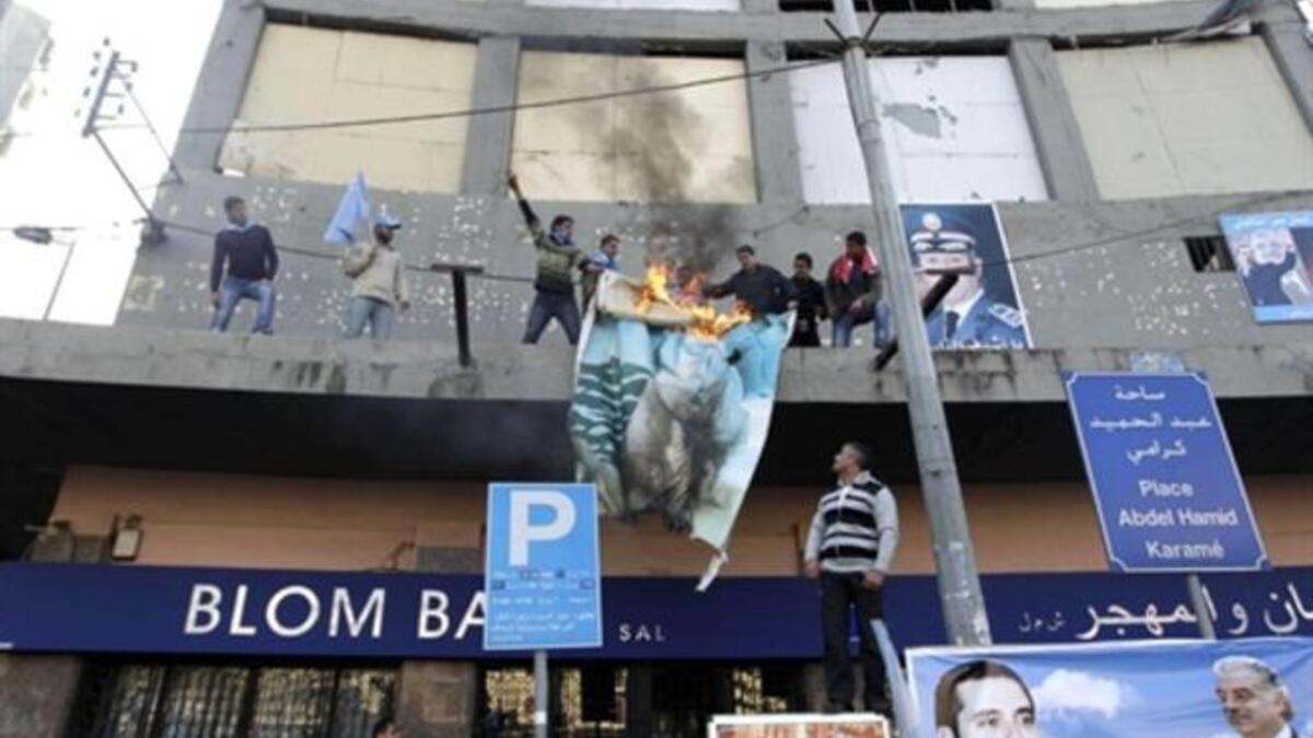 Supporters of the Future Movement torch a poster of Lebanese MP Najib Mikati during a demonstration in support of the caretaker prime minister Saad Hariri in the Sunni bastion coastal city of Tripoli north of Beirut.