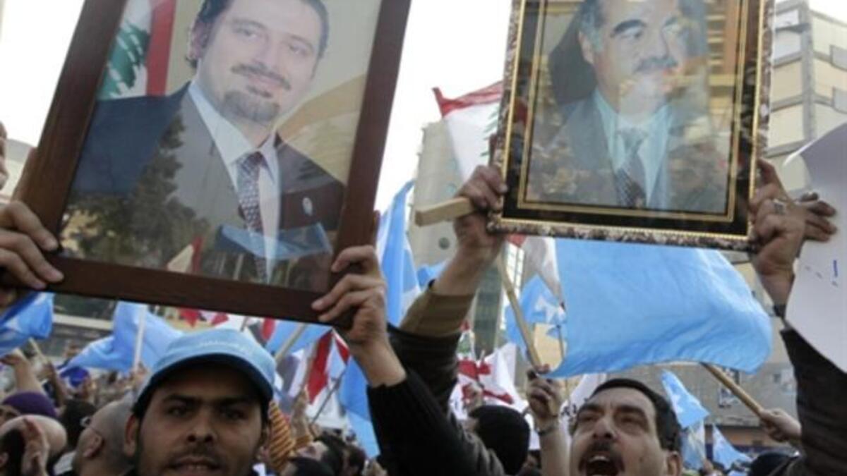 Holding up images of caretaker prime minister Saad Hariri (L) and his late father Rafiq (R) Lebanese supporters of the Future Movement.