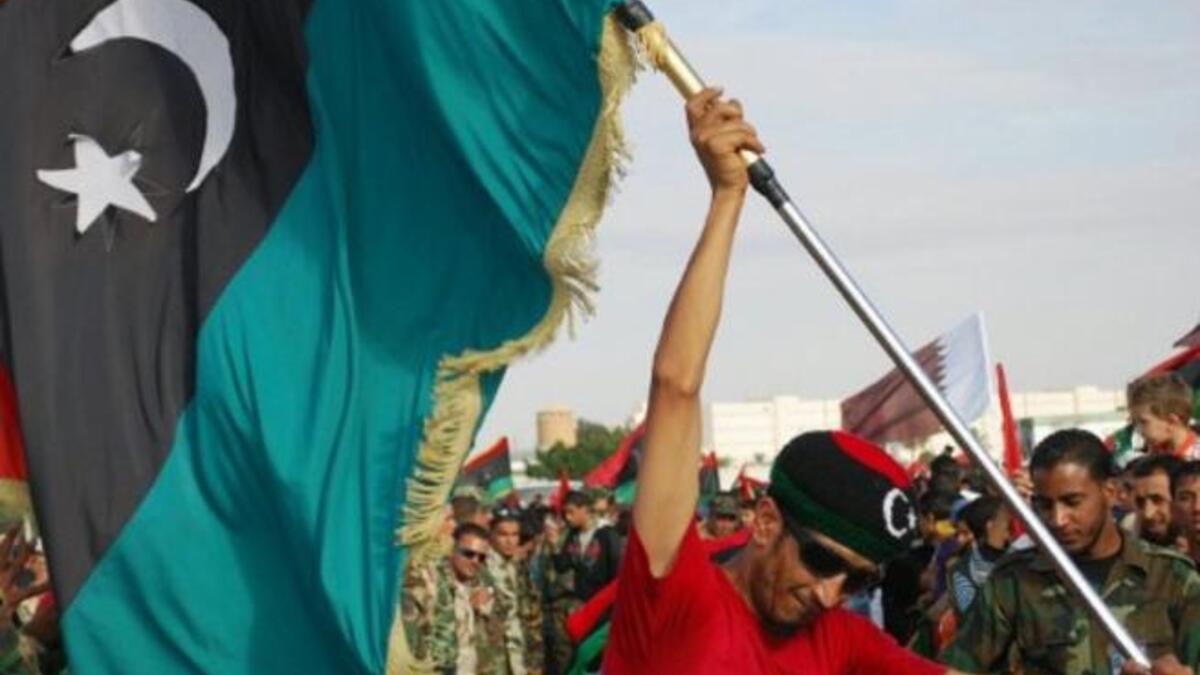 A Libyan man waves his new national flag during a ceremony announcing the liberation for the country in the eastern city of 
Benghazi. The new flag chimes in with the new chapter of hope for Libya. It also promises a return to Islamic values, 
with the reinstatement of rights to marry more than one wife, as well as exclusively Islamic banking.
