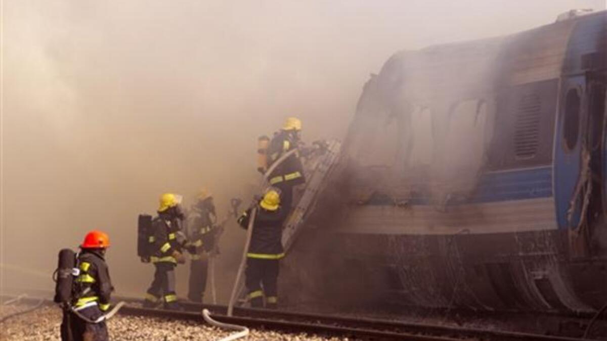 Israeli fire fighters spray water to extinguish the flames of a burning train coach near Kibbutz Shfaim, close to the Israeli city of Netanya about 15 kms north of Tel Aviv, after the passenger train cought fire, injuring almost 50 people, in an apparent accident.