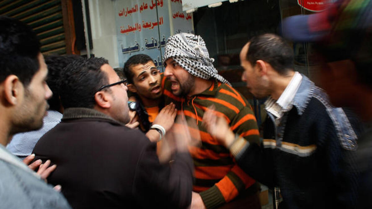 Egyptians regroup and argue about strategy in a side alley during a clash between pro- and anti-Mubarak protesters.