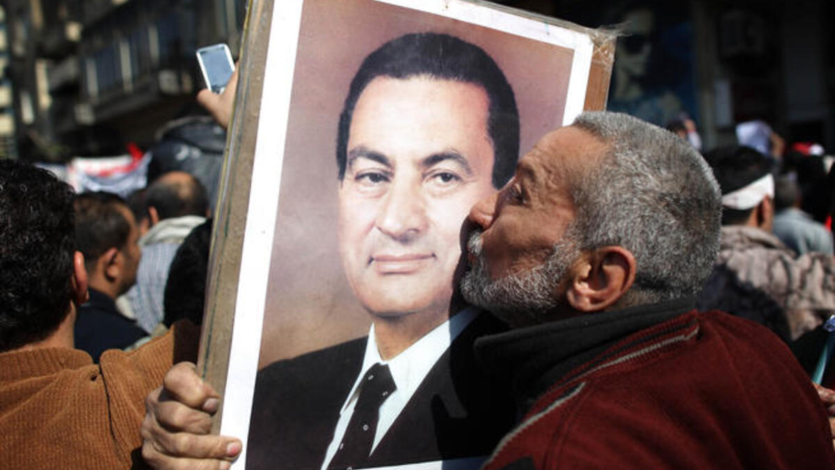 A man kisses a photograph of President Hosni Mubarak during a pro-government demonstration.