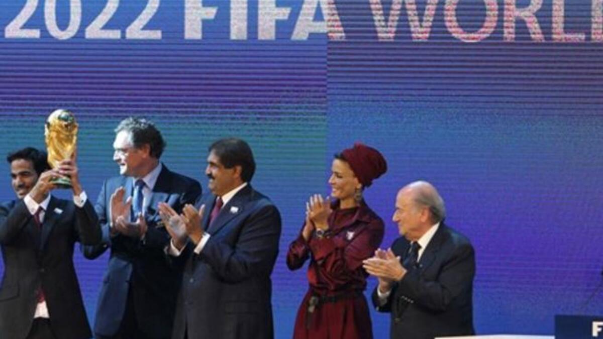 Sheikh Mohammed bin Hamad al-Thani, chairman of the Qatar 2022 bid committee, (L) raises the World Cup trophy as he stands with Qatar's Emir Sheikh Hamad bin Khalifa al-Thani (C), his wife Sheikha Moza and FIFA president Joseph Blatter (R).