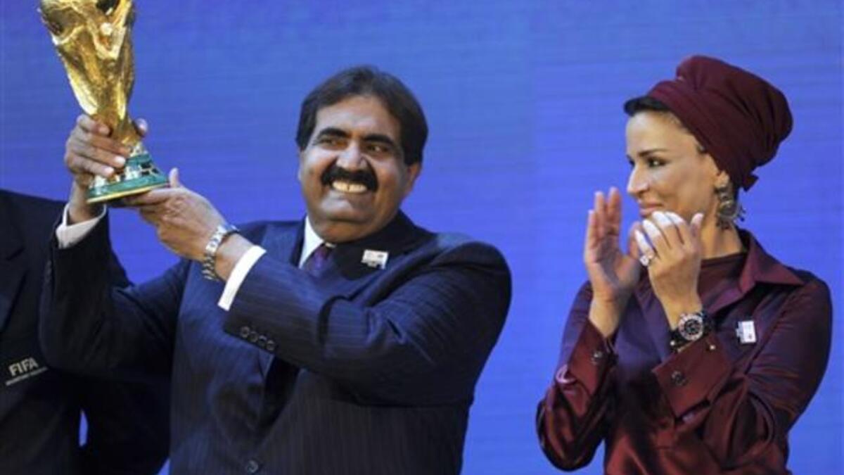 Emir of the State of Qatar Sheikh Hamad bin Khalifa Al-Thani (L) poses by his wife Sheikha Moza bint Nasser Al-Missned with the World Cup trophy after the official announcement that Qatar will host the 2022 World Cup.