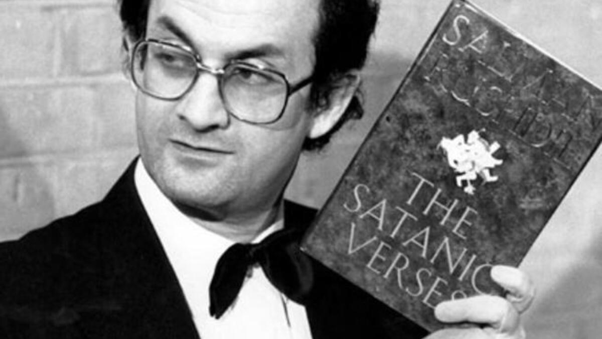 Salman Rushdie brandishes his novel Satanic Verses