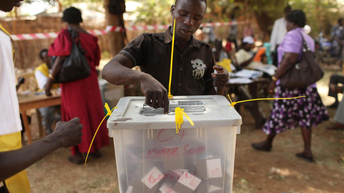 A man places his vote in a plastic box at a polling station.