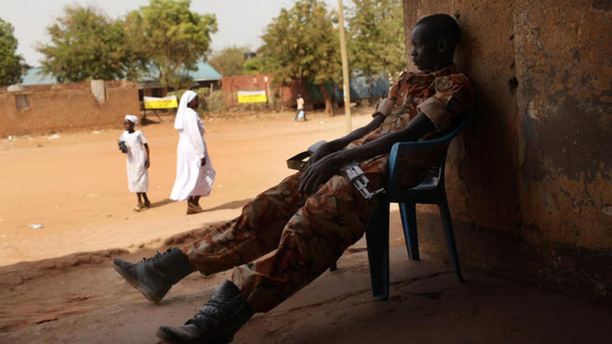 A south Sudanese police officer guards a polling station.