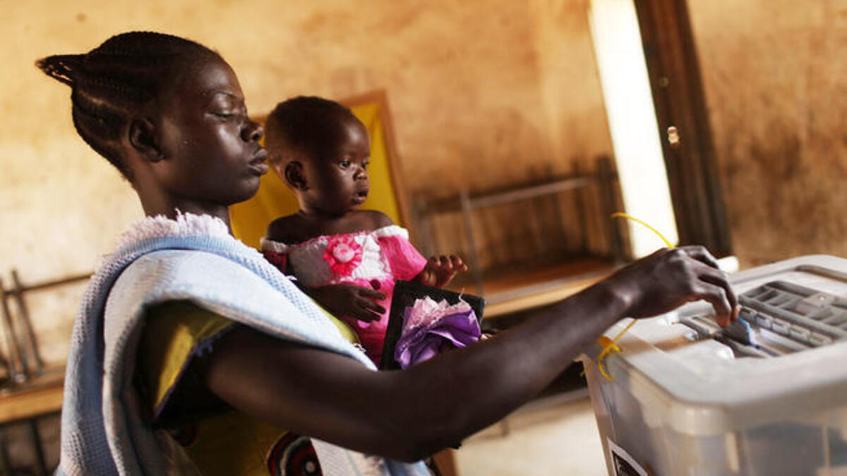 A woman votes with her daughter at a polling station.