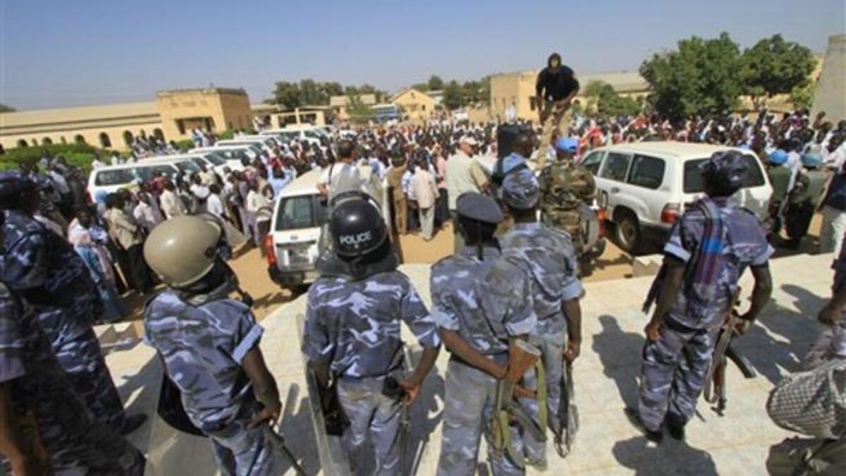 Sudanese policemen stand guard as university students gather during a protest against the visit of Darfur mediators from Qatar and the UN outside the University of Zalingei in western Darfur.