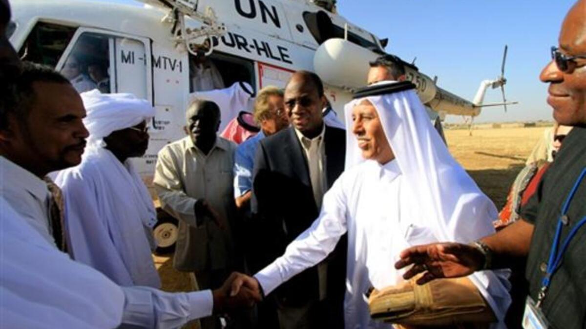 Djibril Bassole, chief negotiator for the UN and the African Union, and Qatari Minister of State for Foreign Affairs Ahmed bin Abdullah al-Mahmud are greeted by local Sudanese.