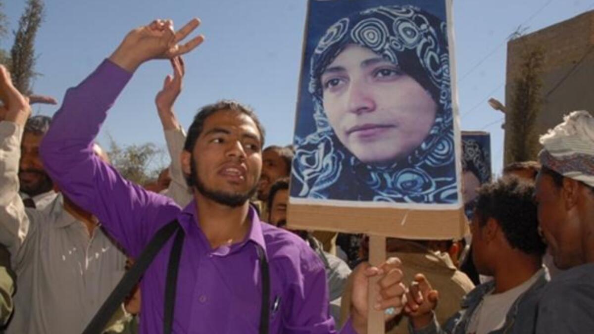 YEMEN: Yemeni protesters, holding up pictures of detained political activist Tawakel Karman protest, January 24, 2011.