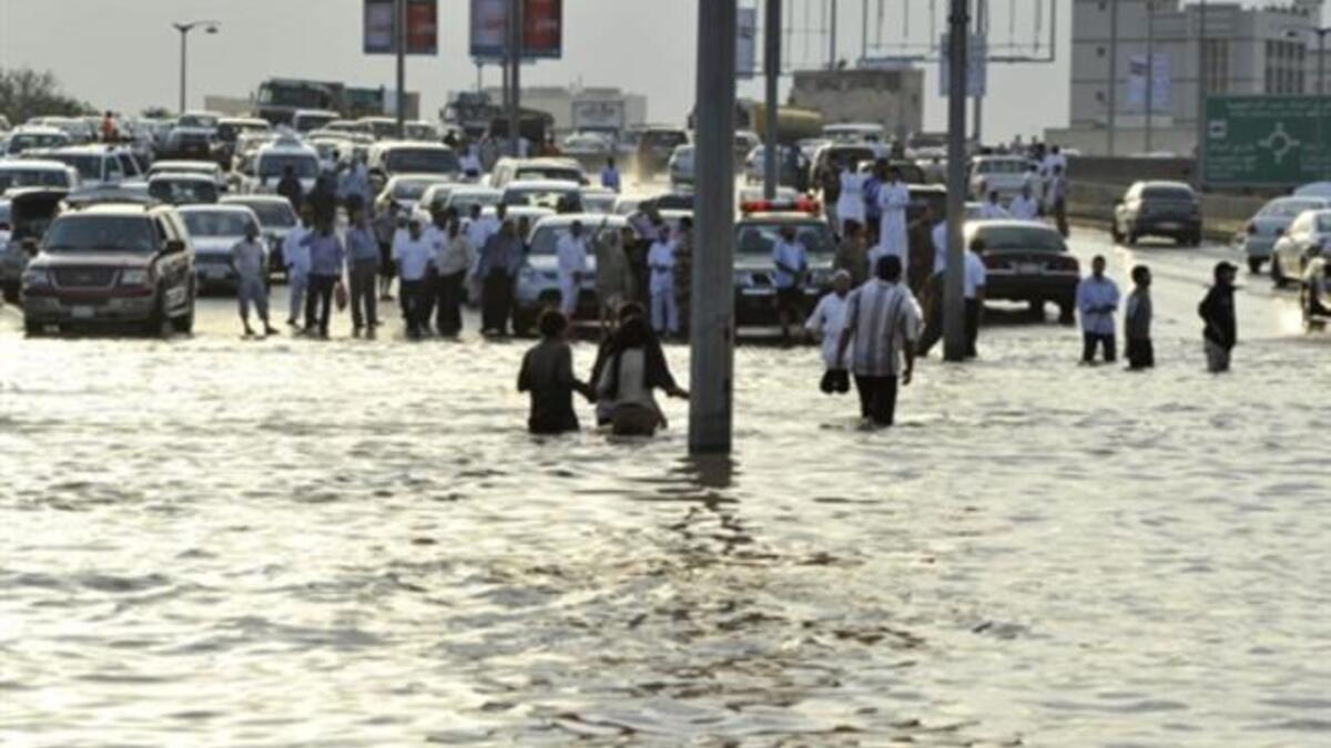 SAUDI ARABIA: Saudi motorists stop their vehicles on the edge of a flooded street following heavy rain in the Red Sea port city of Jeddah, January 26, 2011.