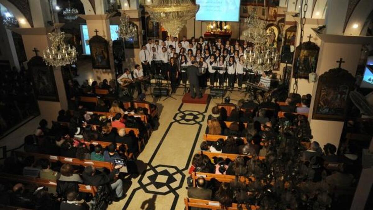Syria christmas celebrations include choirs singing to a burning backdrop.