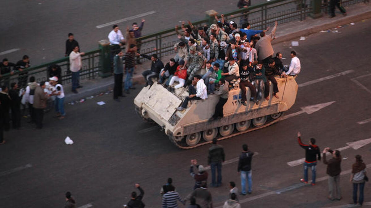 Protesters ride an armored personnel carrier towards the Nile.