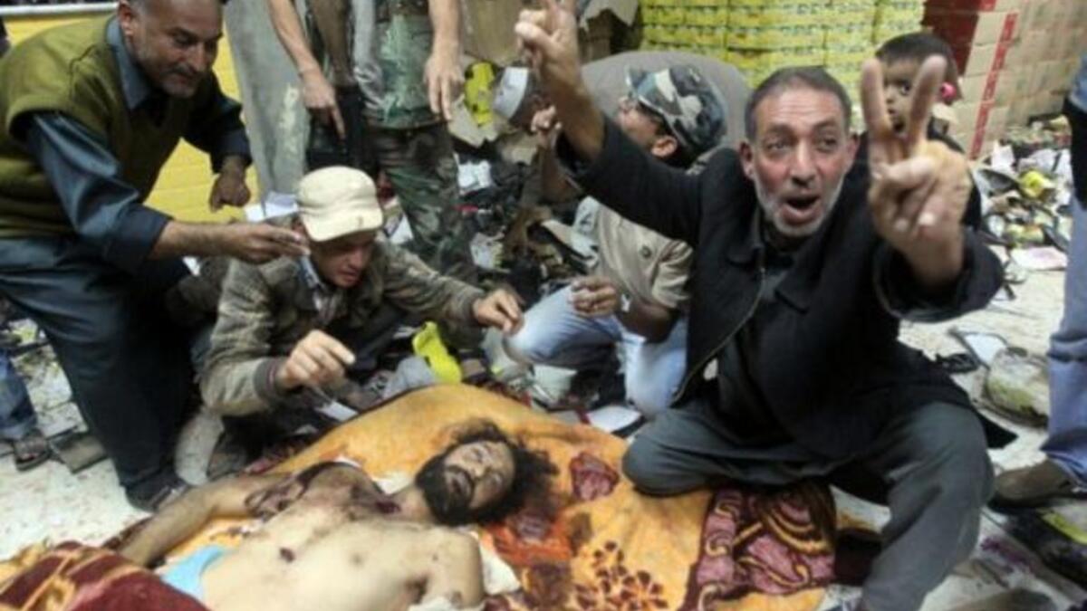 Libyans celebrate over the body of Mutassem Gaddafi, in Misrata. Killed with father as new regime forces finally breached their hide-out in hometown Sirte. They particularly disrespected him because of his notorious 'playful' lifestyle, frowned upon in a conservative country. He also stood as a contender to the 'throne,' challenging brother Saif.