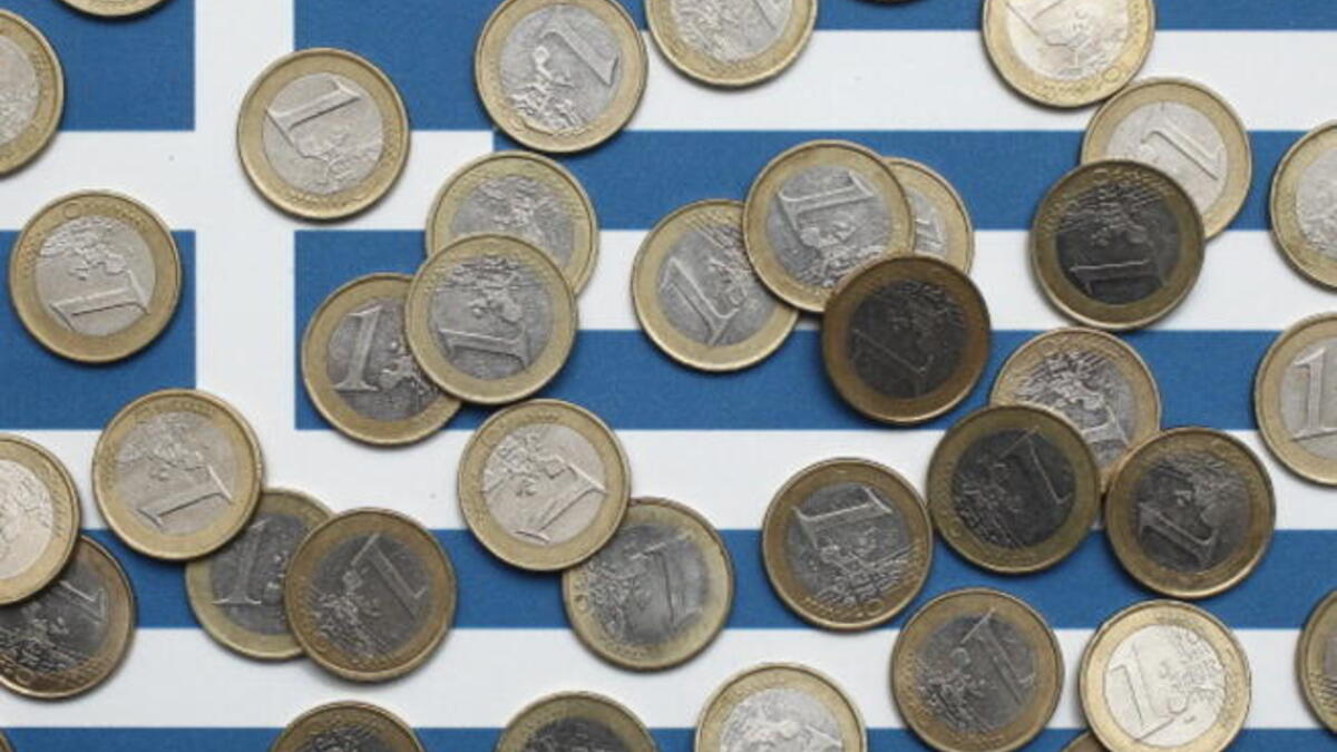 Euro coins atop a Greek flag
