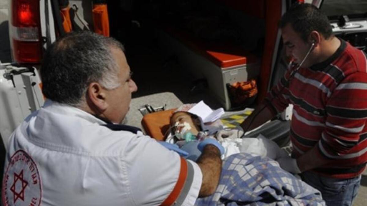 Israeli and Palestinian paramedics treat a wounded Palestinian boy being transfered for medical treatment to an Israeli hospital after he was injured in an Israeli army attack on the Palestinian Gaza Strip.