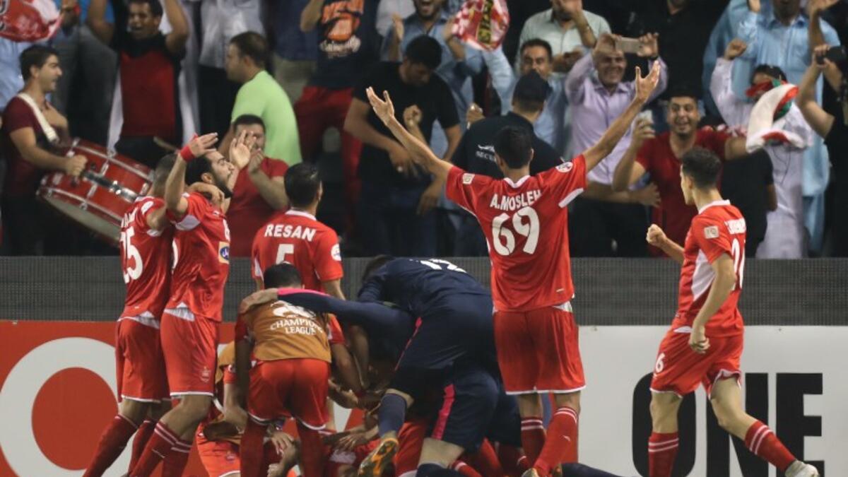 Persepolis FC's Ali Alipour (unseen) celebrates with teammates after scoring during the AFC Champions League semi-final first leg match between Al-Sadd SC FC and Persepolis FC at the Jassim Bin Hamad Stadium in Doha on October 2, 2018.
KARIM JAAFAR / AFP