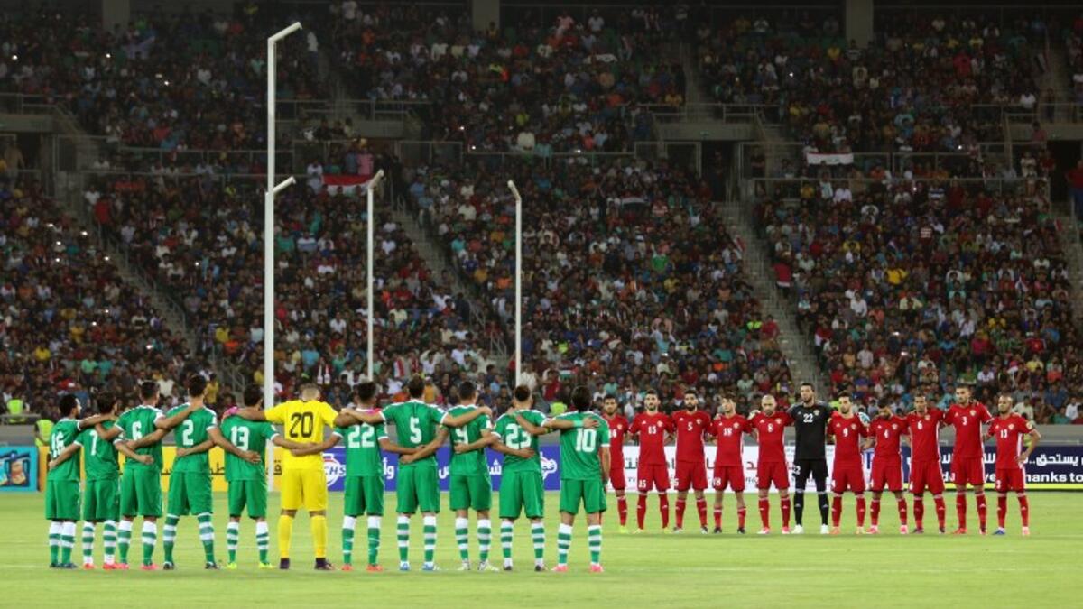 Iraq's (L) and Jordan's starting eleven obeserve a moment of silence ahead of their international friendly football match between Iraq and Jordan at Basra Sports City in Basra on June 1, 2017.
HAIDAR MOHAMMED ALI / AFP