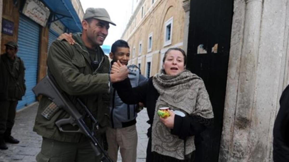A Tunisian soldier shakes hands with Tunisian people in la Kasbah of Tunis.