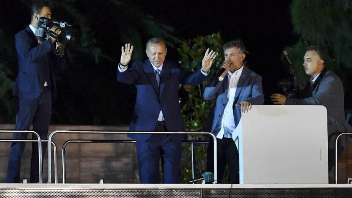 Turkish President Recep Tayyip Erdogan (C) waves to suppporters in Istanbul on June 24, 2018, during Turkey's presidential and parliamentary elections. Erdogan on June 24 declared victory in a tightly-contested presidential election. (AFP/ Bulent Kilic)