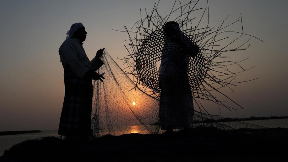 Emirati men weave a fishing net during the Dalma Sailing Festival, off of the coast of Dalma island in the Persian Gulf, about 40 kilometres off of the Emirati capital Abu Dhabi on October 27, 2018. (KARIM SAHIB / AFP)