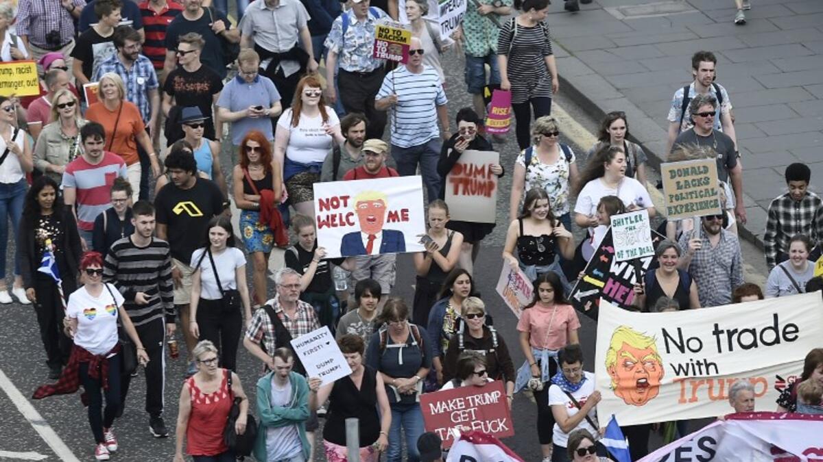 Protestors carry placards as they take part in the Scotland United Against Trump demonstration through the streets of Edinburgh, Scotland on July 14, 2018, on the third day of US President Donald Trump's four-day UK visit. (NEIL HANNA / AFP)