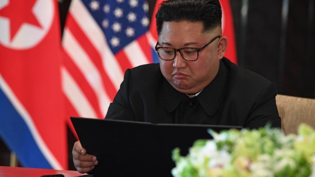 North Korea's leader Kim Jong Un looks at his document at a signing ceremony with US President Donald Trump (not pictured) during their historic US-North Korea summit, at the Capella Hotel on Sentosa island in Singapore on June 12, 2018. (SAUL LOEB / AFP)