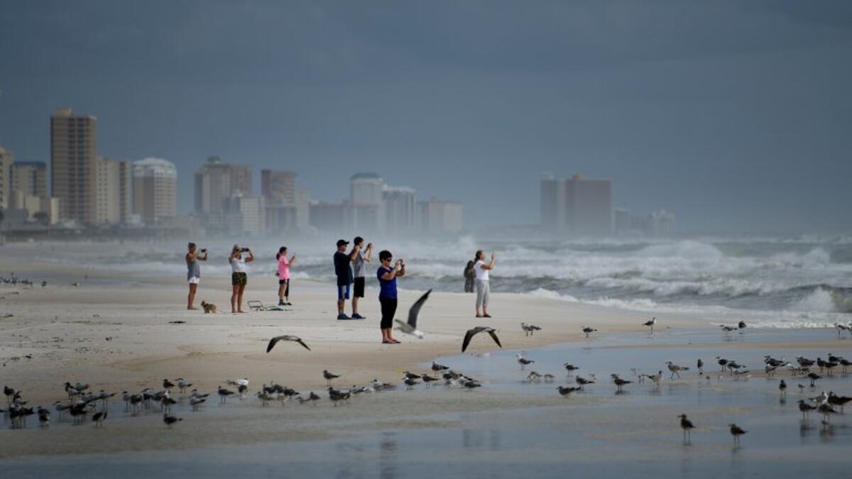 People look out to the Gulf of Mexico as Hurricane Michael approaches October 9, 2018 in Panama City Beach, Florida Hurricane Michael strengthened to a Category 2 storm with winds over 100 miles per hour on Tuesday. (Brendan Smialowski / AFP)