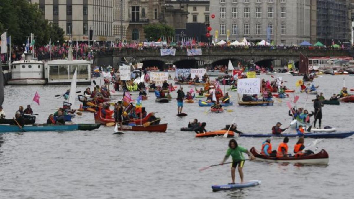 متظاهرون يركبون قوارب في بحيرة إينر ألستر احتجاجًا على القمة.