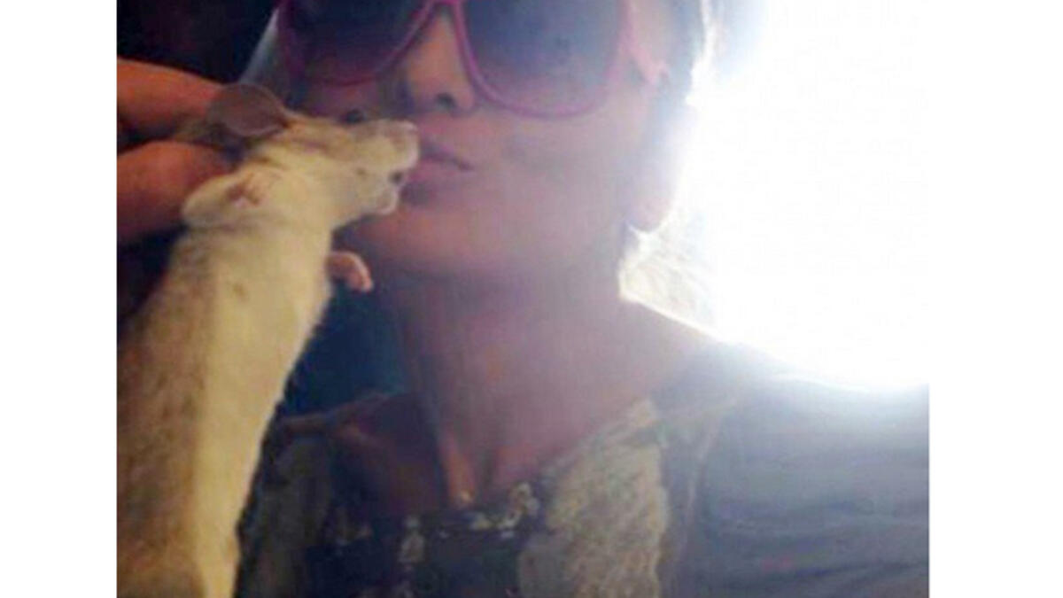 Gimme a kiss: Randa al Buhairi gives a hamster a peck on the cheek! (Image: Al Jaras Magazine)